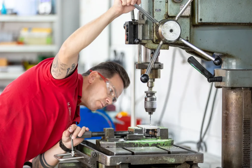 Mitarbeiter an der Standbohrmaschine